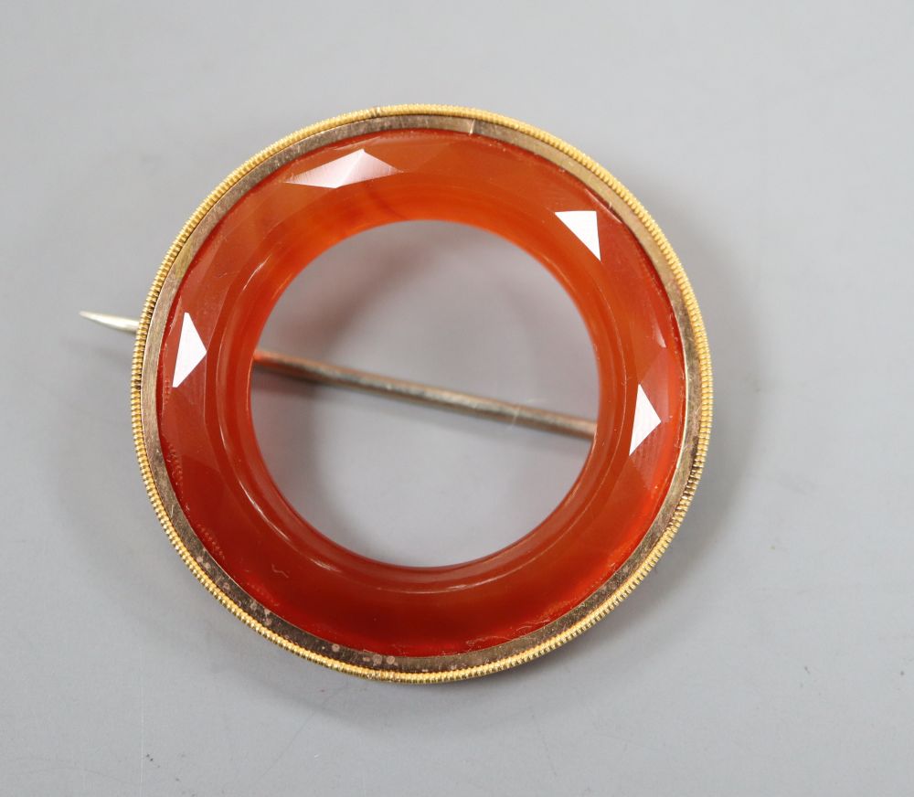 A yellow metal mounted facetted agate openwork circular brooch, 36mm, gross 8.4 grams.